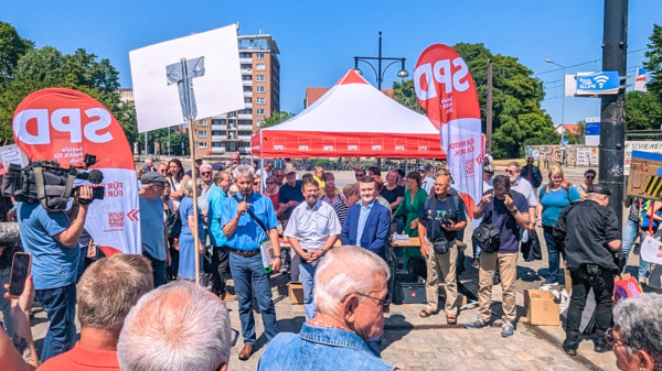 Matthias Schreiter, Rainer Albrecht und Thoralf Sens vor dem SPD-Stand umringt von interessierten Gartenfreunden auf dem Neuen Markt.