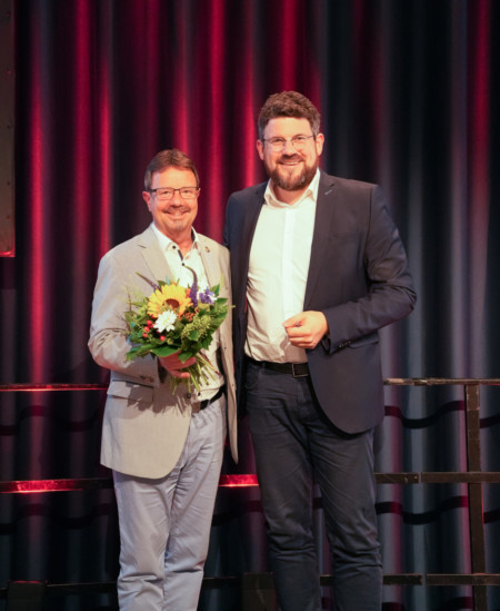 Links Rainer Albrecht mit Blumenstrauß und rechts daneben der frühere Vorsitzende Julian Barlen.